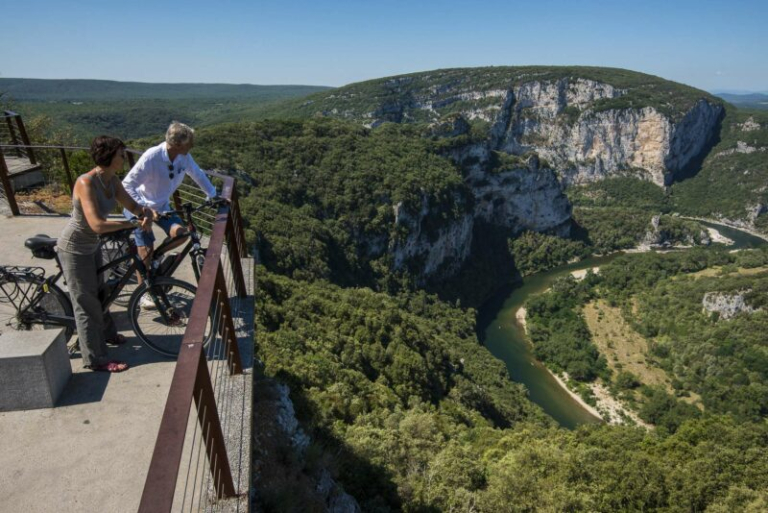 personnes en Vélo électrique sur un des belvédères des gorges de l'Ardèche avec un magnifique panorama.