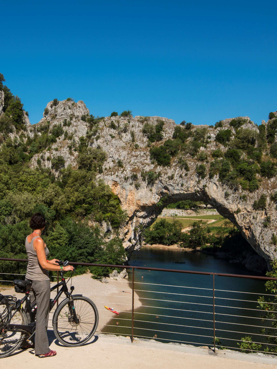 un cycliste regardant le Pont d'arc